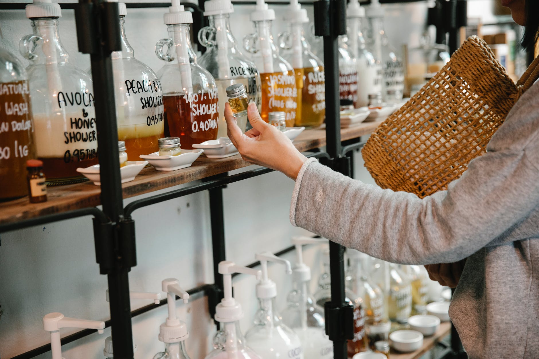 crop customer examining glass jar with shampoo